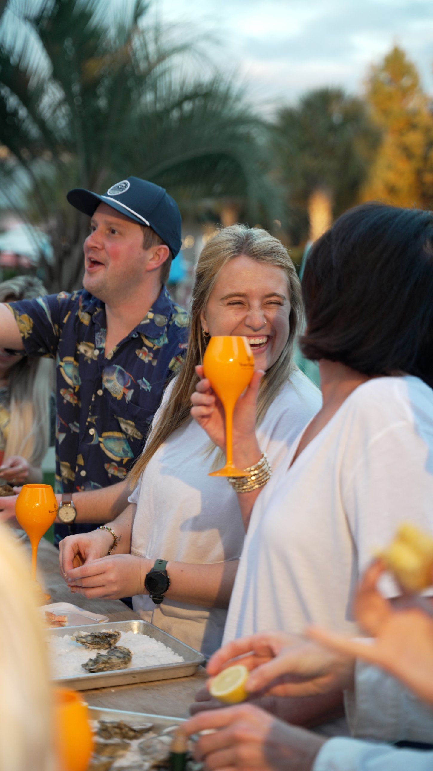 Guests laughing over champagne and oysters