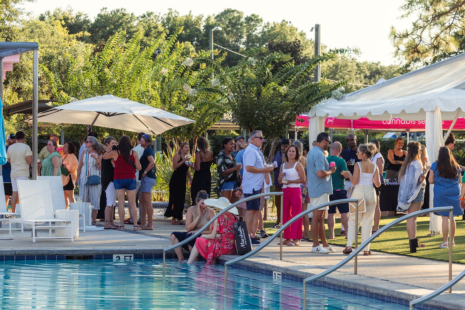 Guests gathered poolside under tents at golden hour